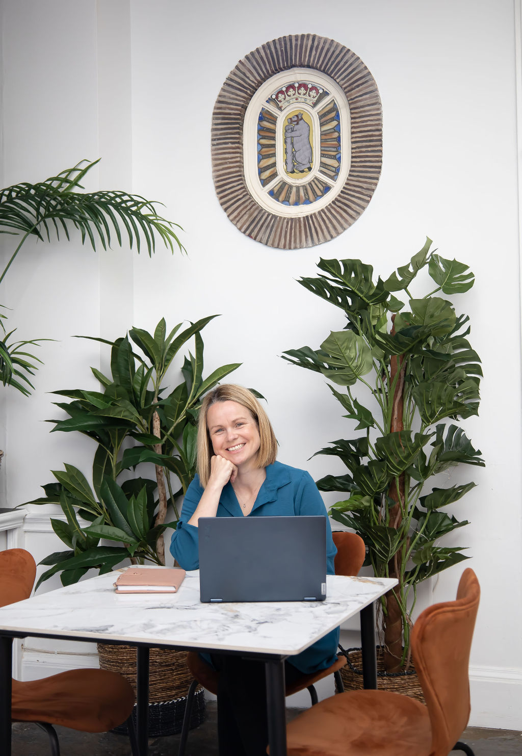 Rachel Brown smiling whilst sitting at a table with a laptop