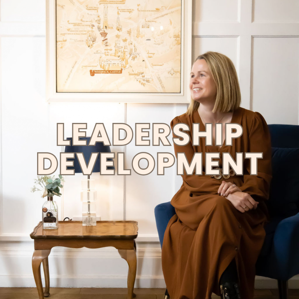 Rachel Brown smiling, sitting on a sofa with a map in the background