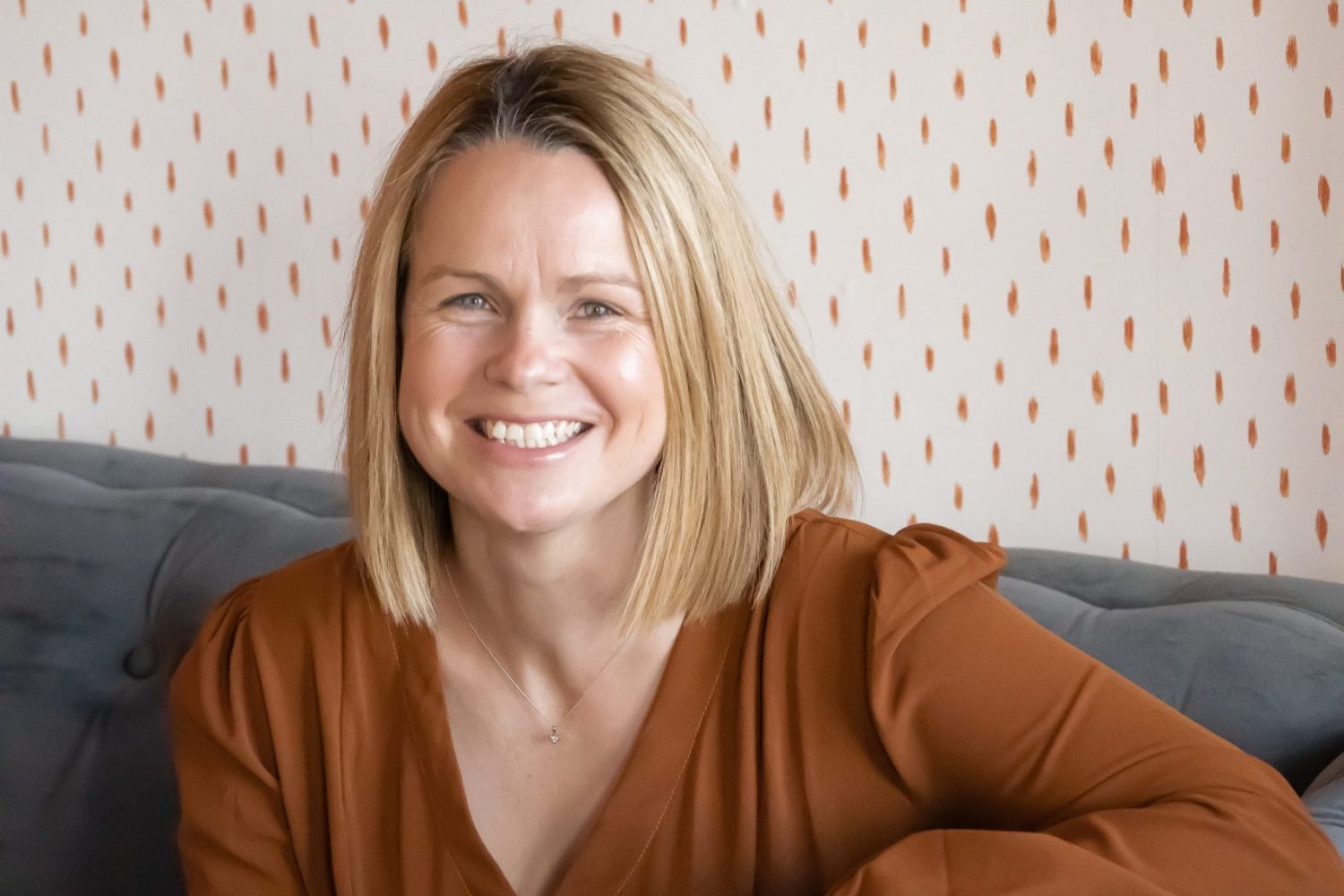 Rachel Brown sitting on a sofa and smiling